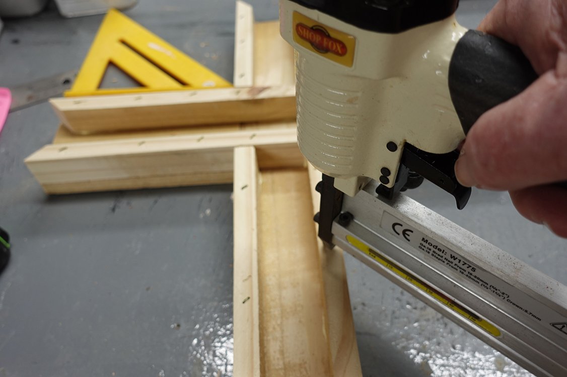 Craftsman assembling a wooden cross in the studio